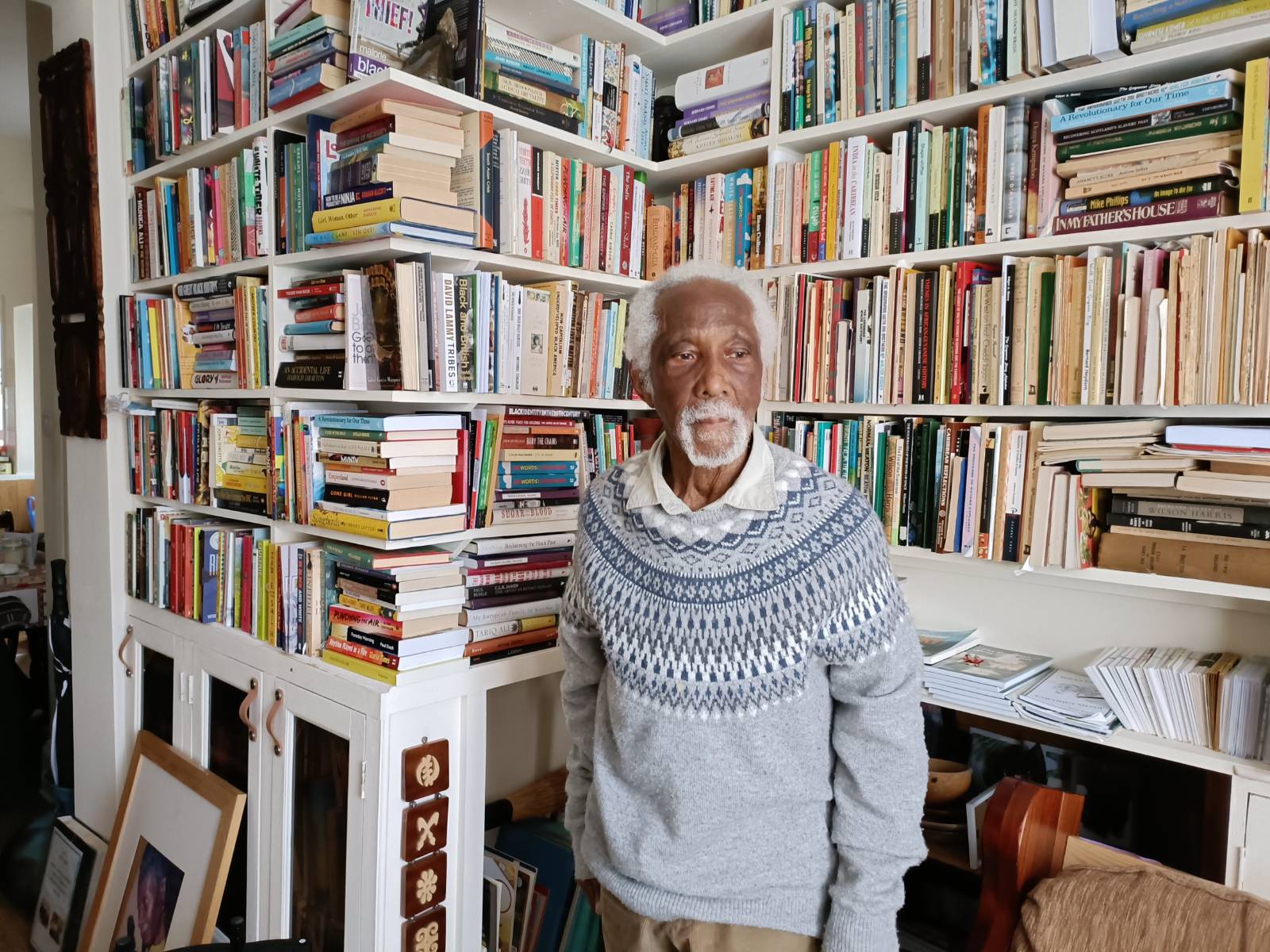 Eric Huntley stands in front of towers of books